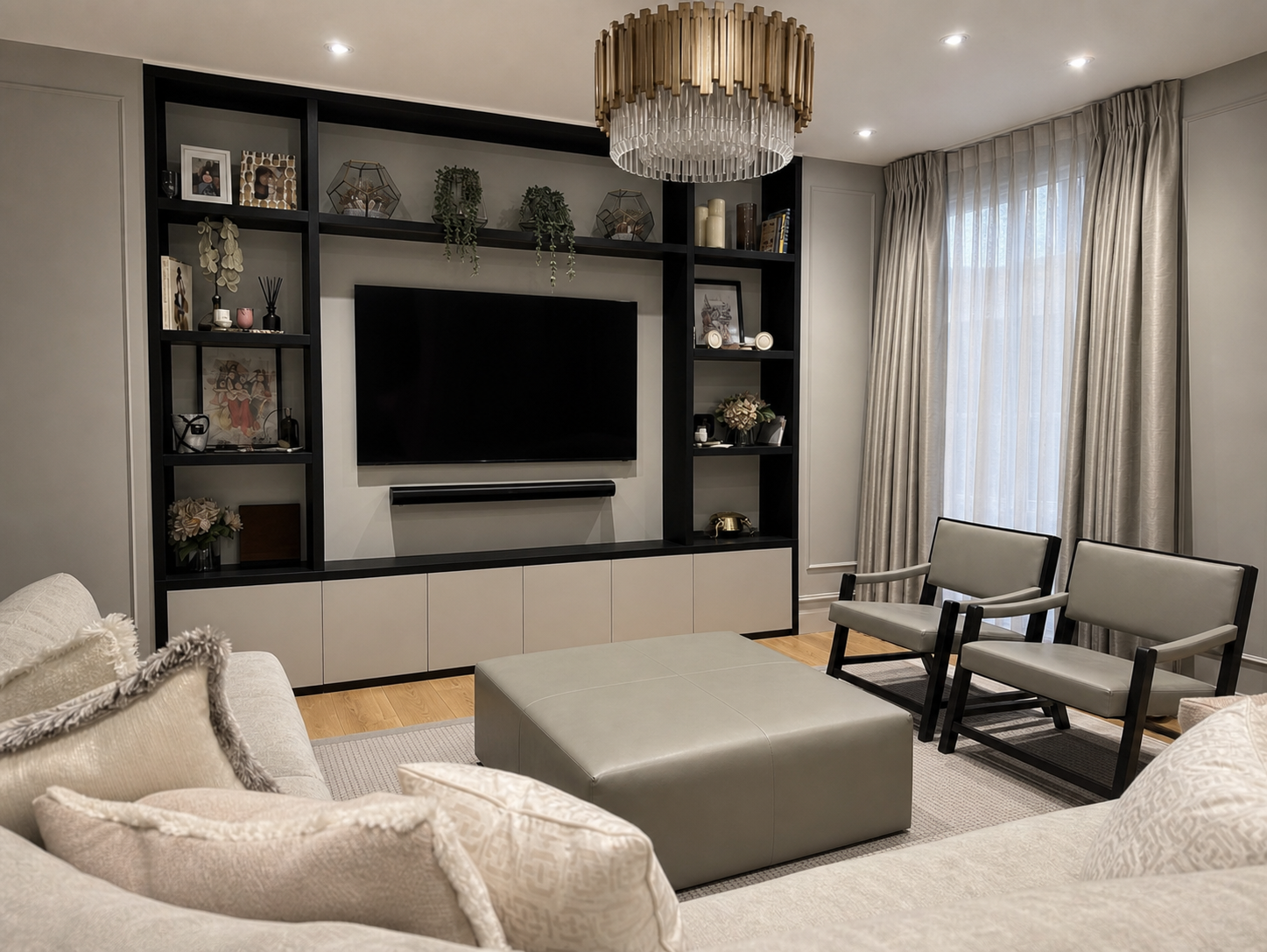 Diagonal view across the pale sofas and central ottoman toward the media wall and window