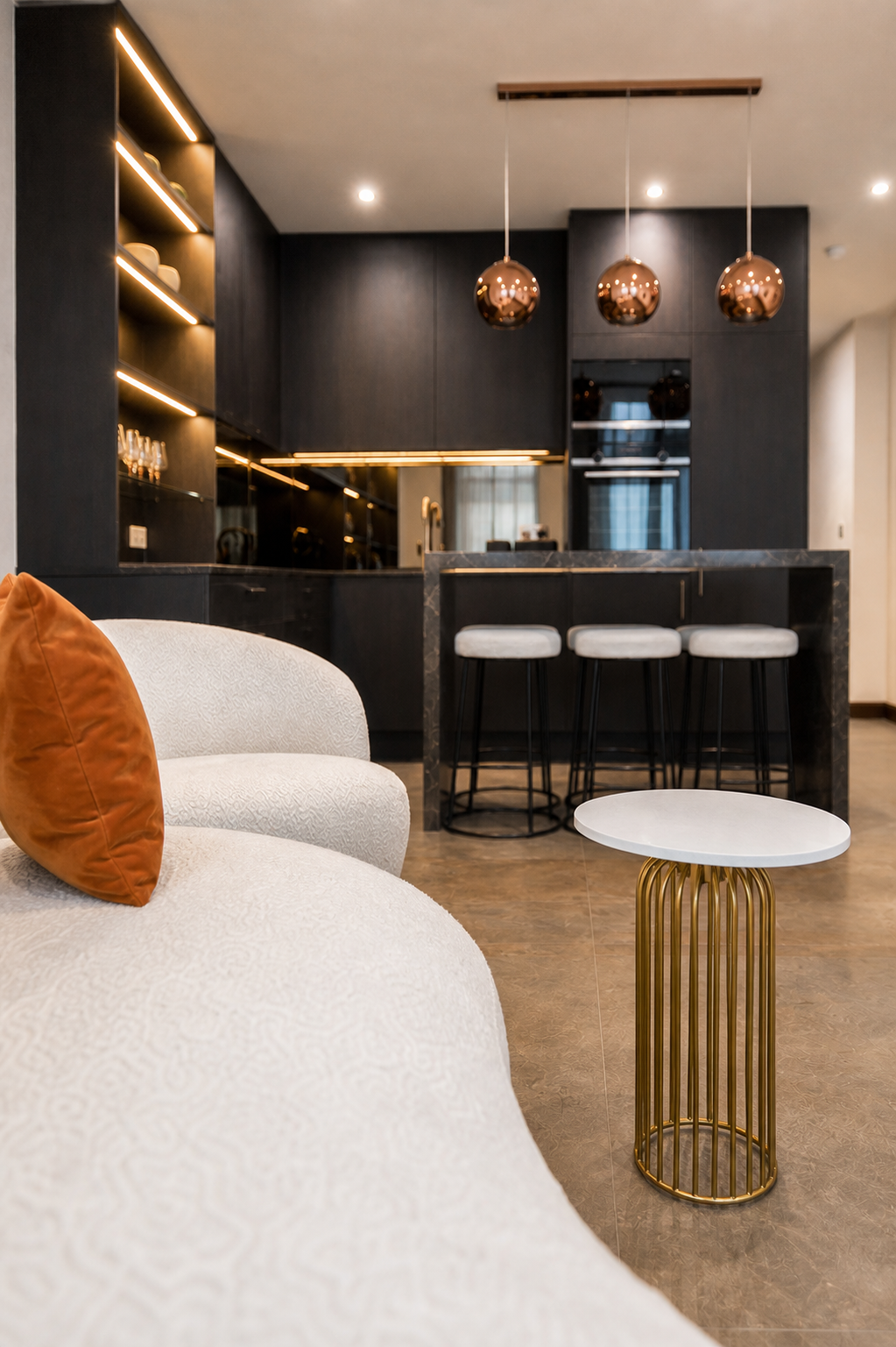 Low lounge view showing white textured seating, an orange cushion and the kitchen beyond