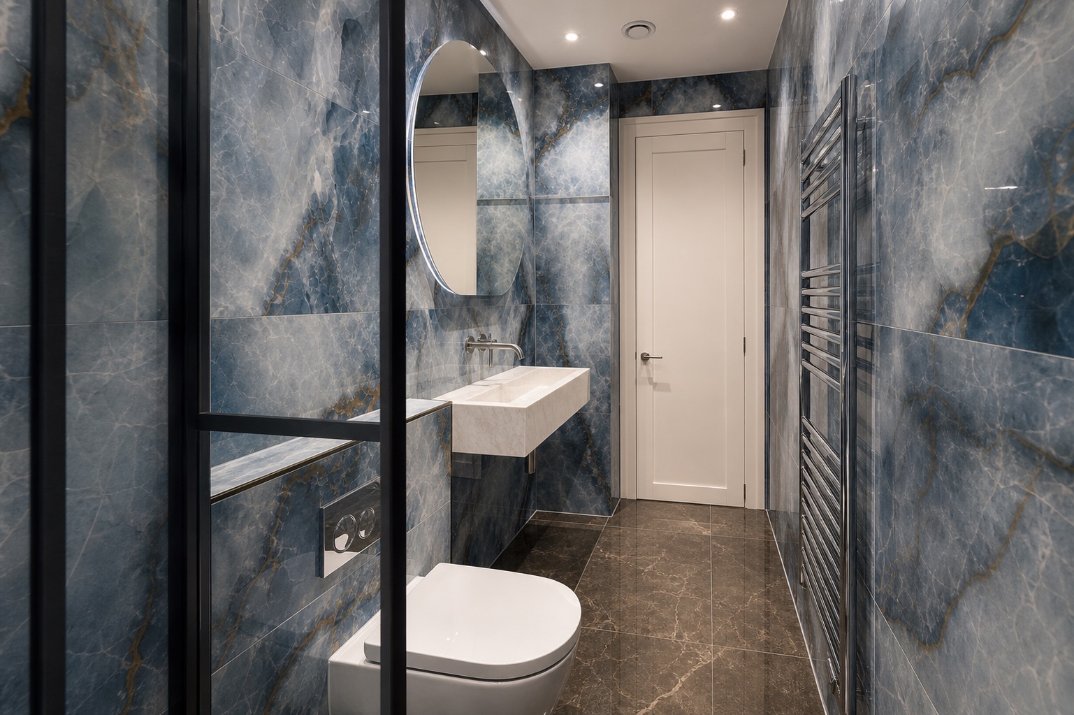 Completed compact London bathroom with blue veined wall slabs, a wall-hung toilet, black-framed shower and white stone basin