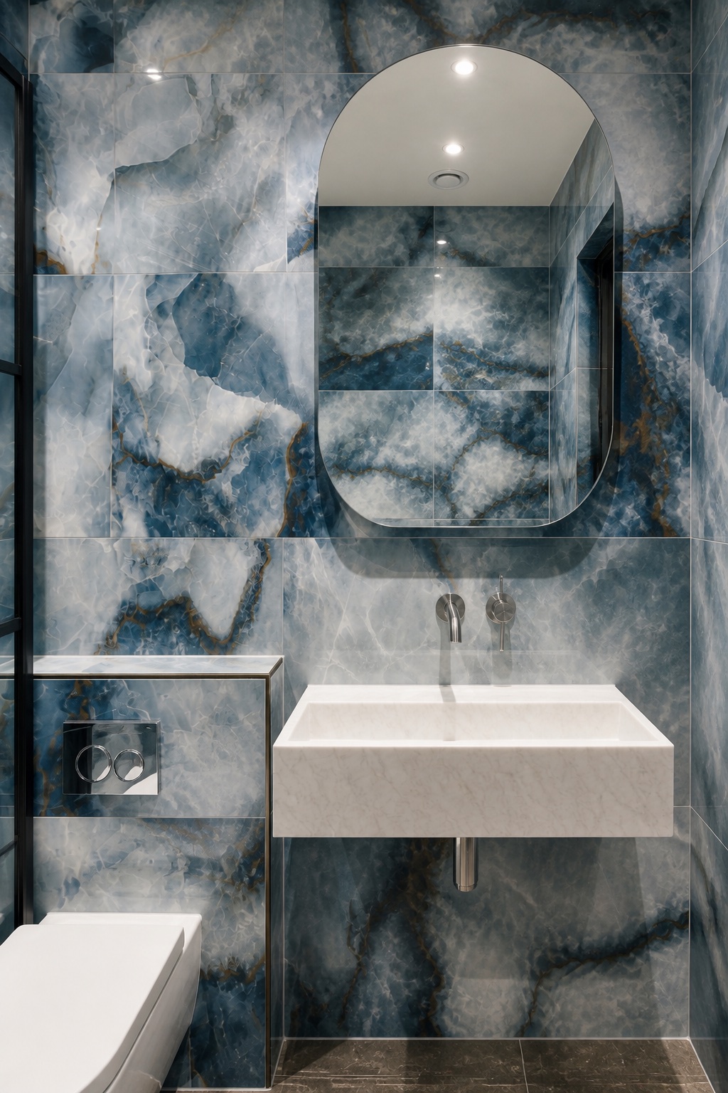 Straight-on view of the white stone trough basin and mirror against blue veined slabs
