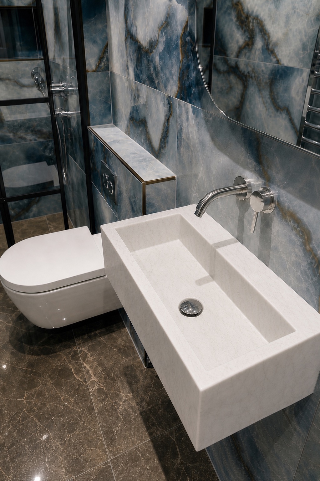 Top-down view into the carved white stone basin and wall-mounted chrome spout