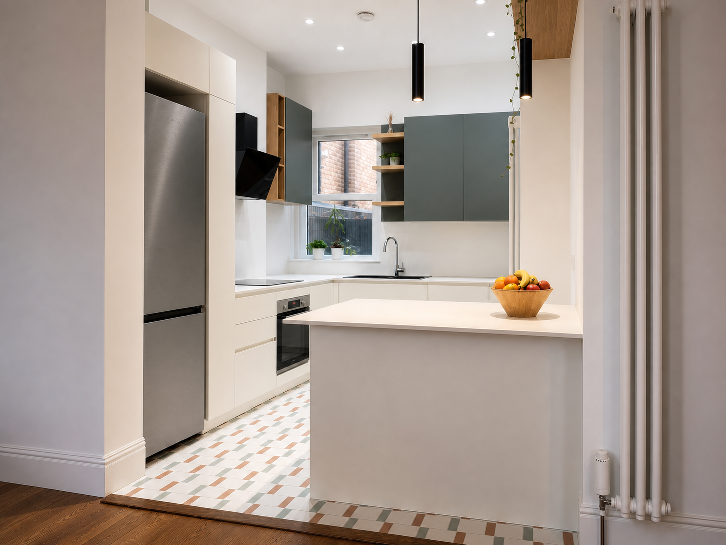 Wide view through the opening toward the white peninsula, two black pendants and completed sage and oak kitchen