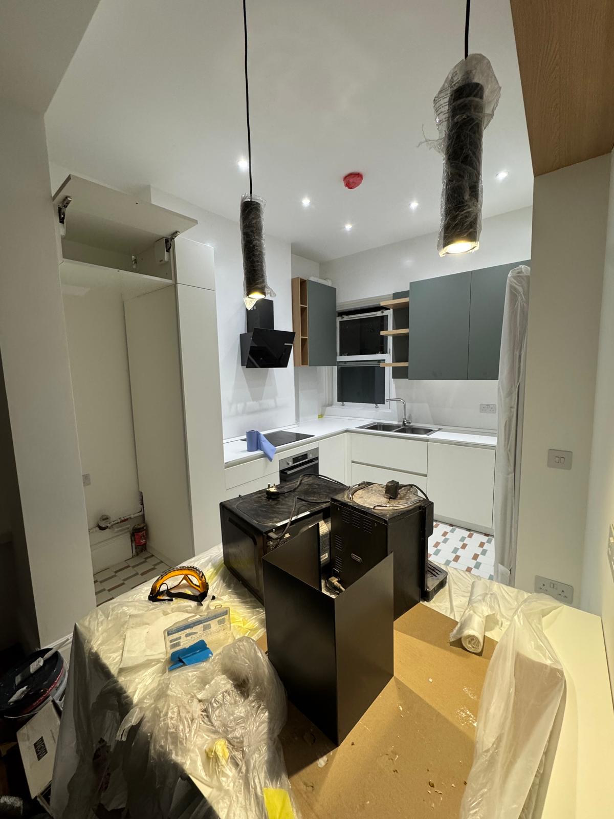 Kitchen cabinetry, pendants and appliances being installed